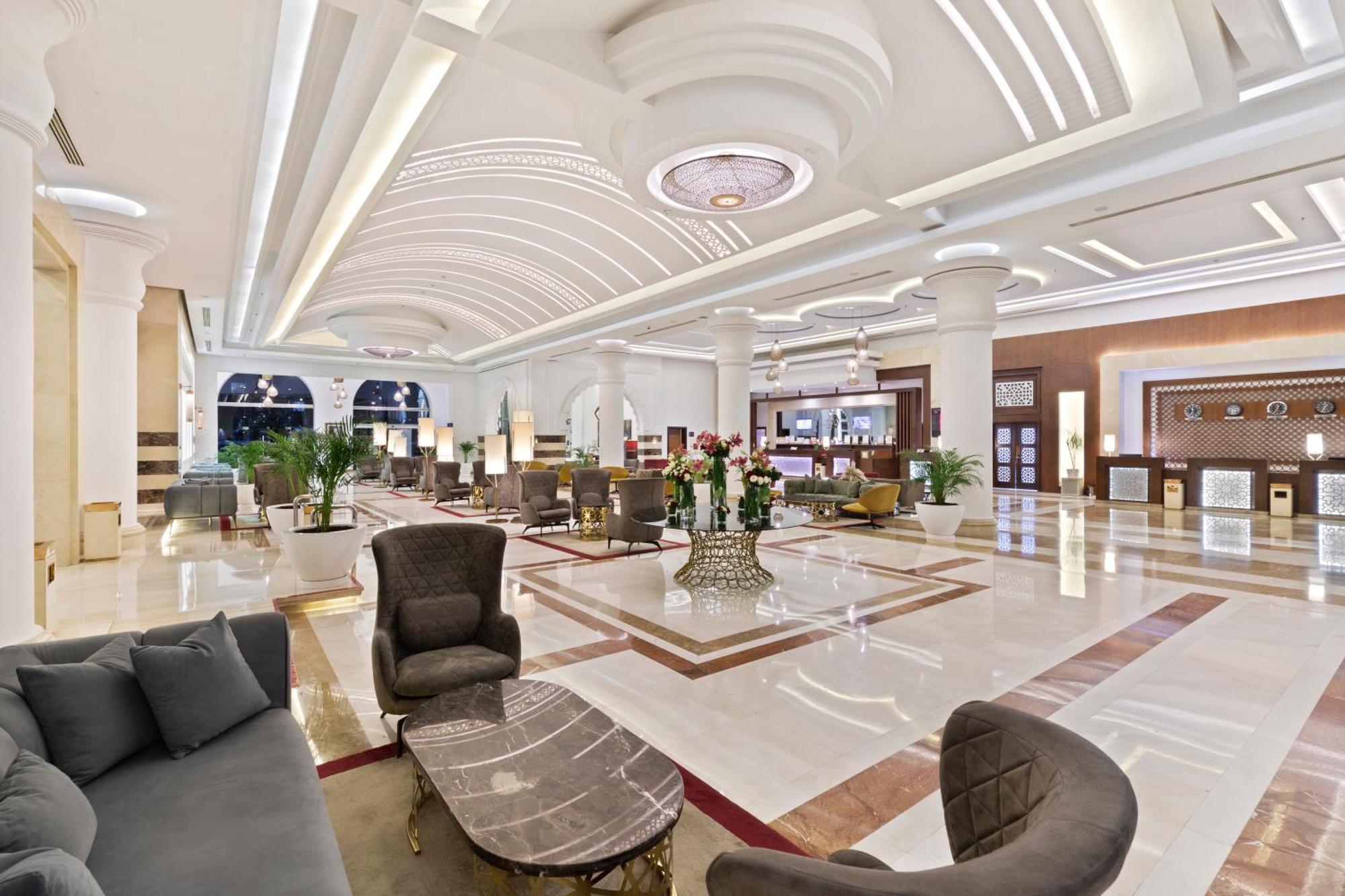 ซาวอย เลอ กร็อง โฮเต็ล มาราเกช Hotel มาร์ราเกช ภายนอก รูปภาพ The image shows a luxurious hotel lobby. The space features high ceilings with elegant architectural details, including decorative lighting fixtures. There are comfortable seating areas with stylish chairs and tables arranged around a central space. 