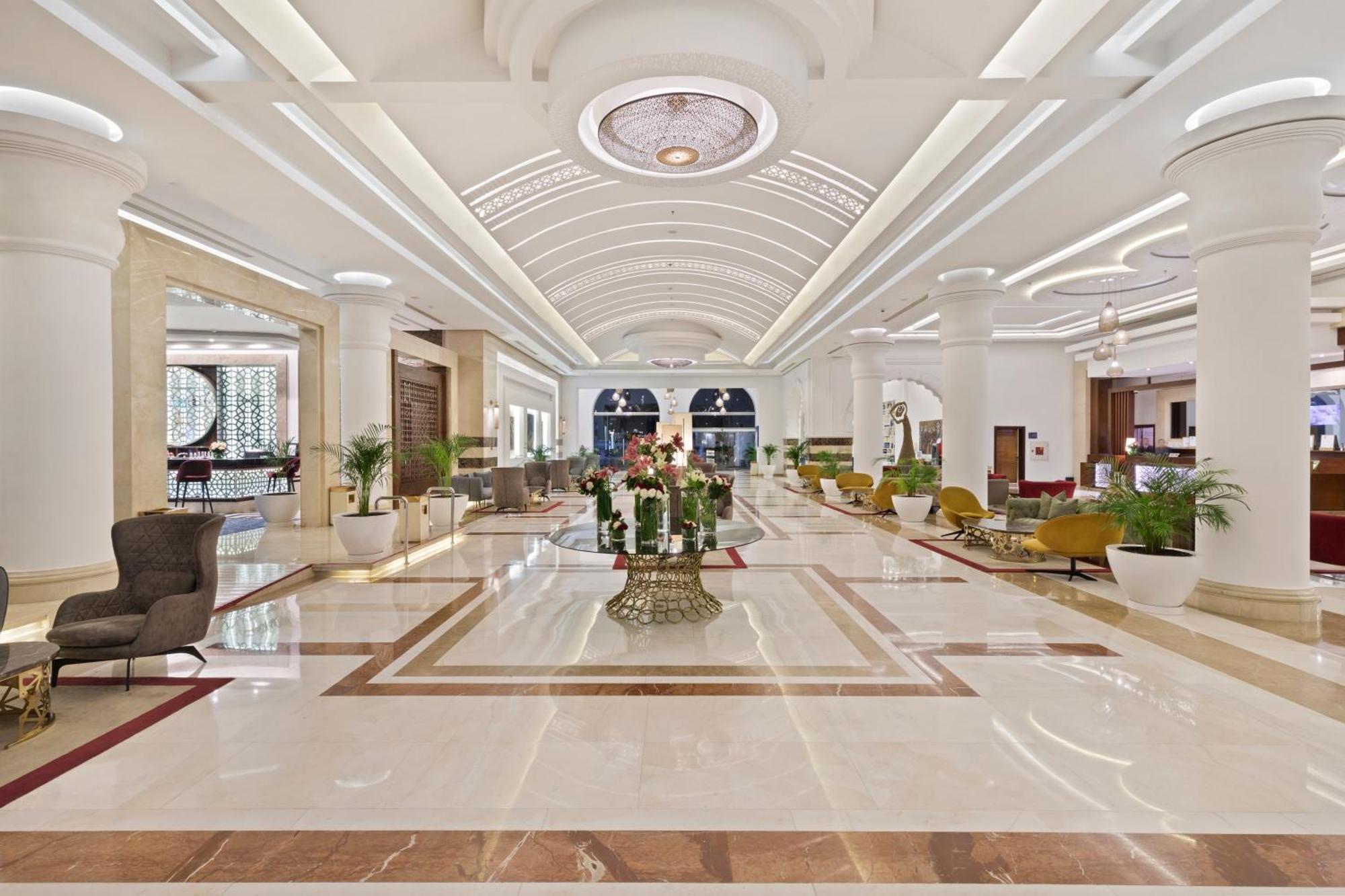 ซาวอย เลอ กร็อง โฮเต็ล มาราเกช Hotel มาร์ราเกช ภายนอก รูปภาพ The photo shows an elegant hotel lobby. It features a spacious and bright area with high ceilings and well-designed architecture. The floor is polished marble, showcasing a luxurious pattern. There are stylish seating arrangements with various chairs